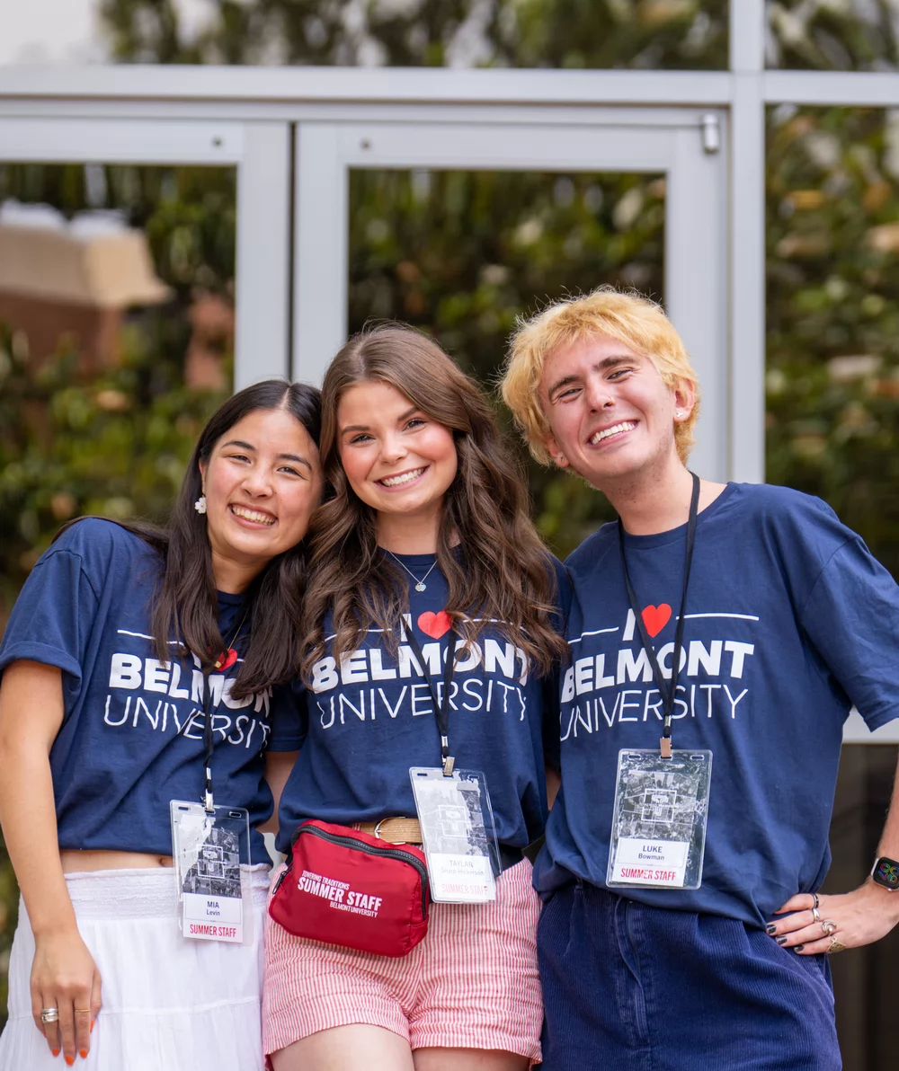 Three students pose together in an embrace