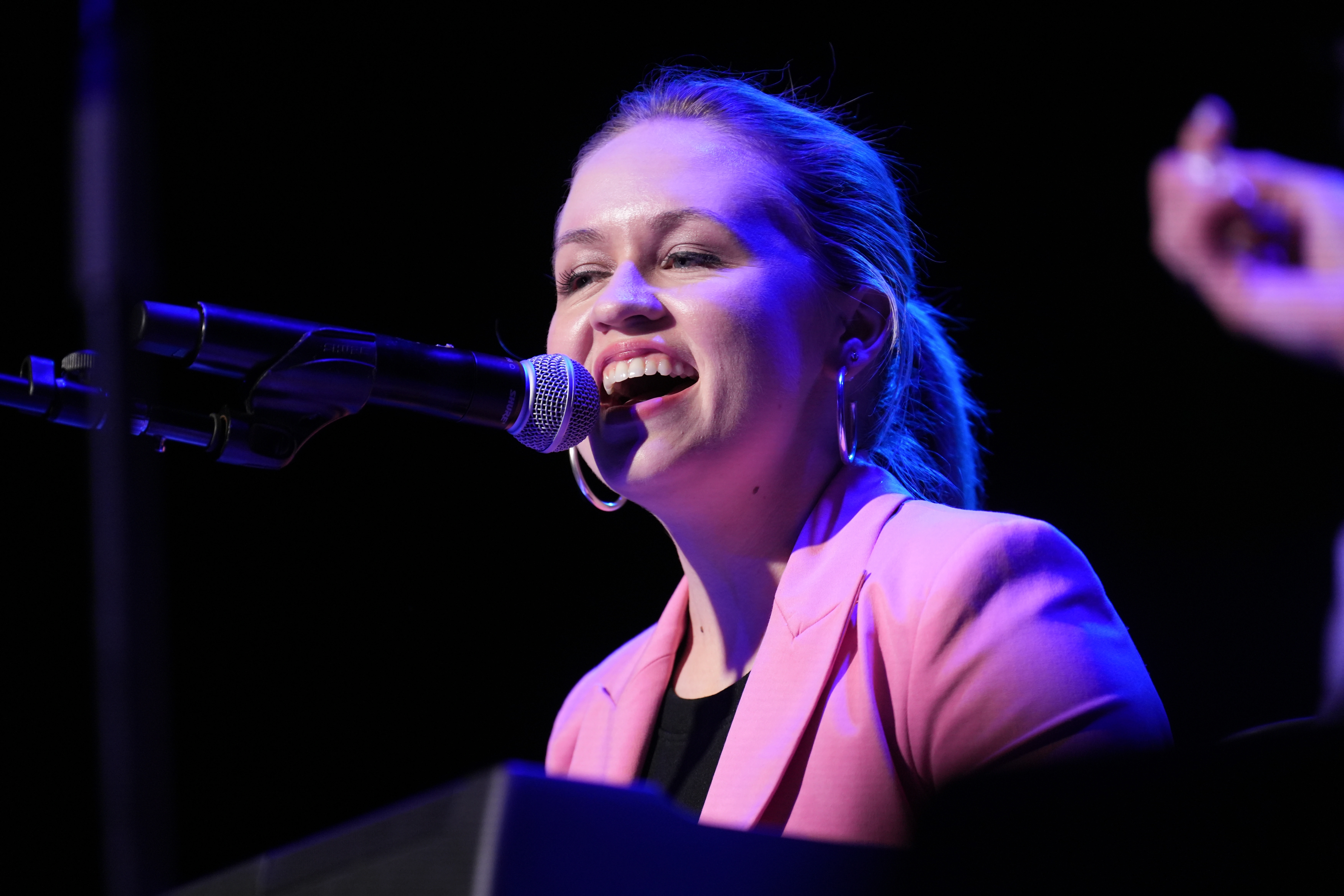 Singer singing into microphone on stage