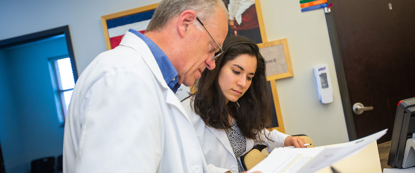 Clinical Faculty member works with a medical student in a clinic.