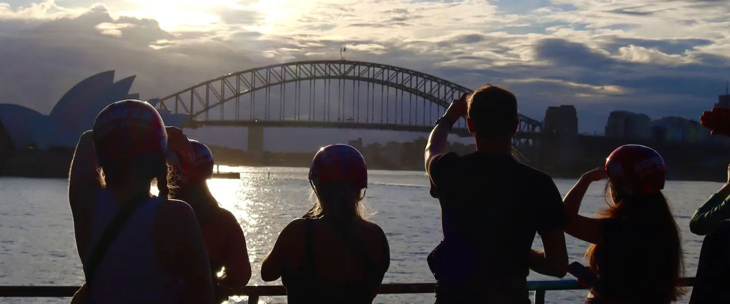 Scenic shot of students looking at a bridge during a sunset
