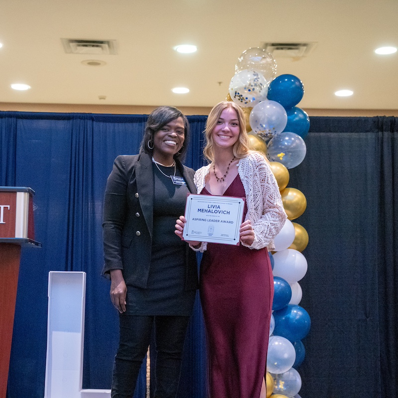 Student and faculty pose with the Aspiring Leader award