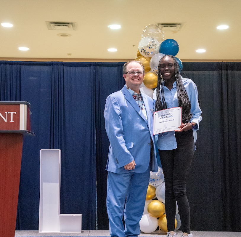 Student and faculty pose with the Champion Award