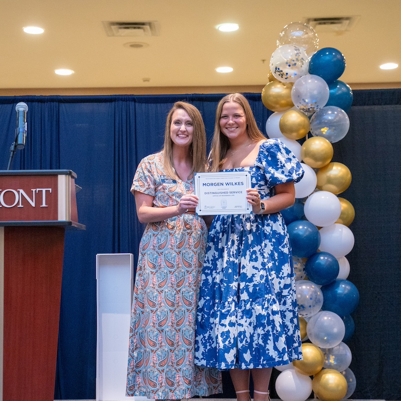 Student and faculty pose with the Residence Life Distinguished Service Award